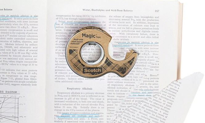 Ruban Scotch® Magic™ 66 % adhésif végétal, sur un livre dont la page est déchirée 
