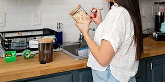 Une femme crée des étiquettes avec un ruban Scotch® Magic™ et les appose à des contenants
